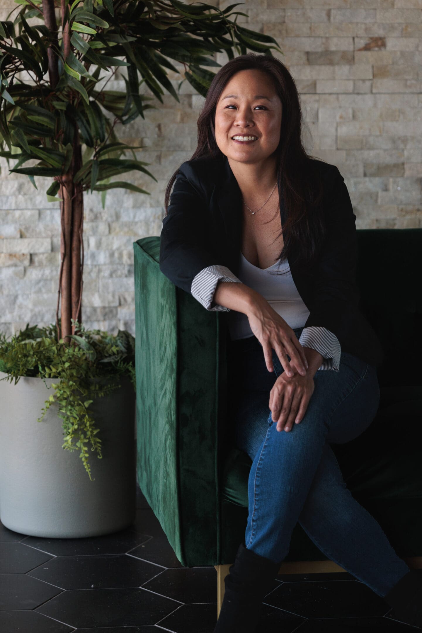 A woman sitting on top of a green chair.