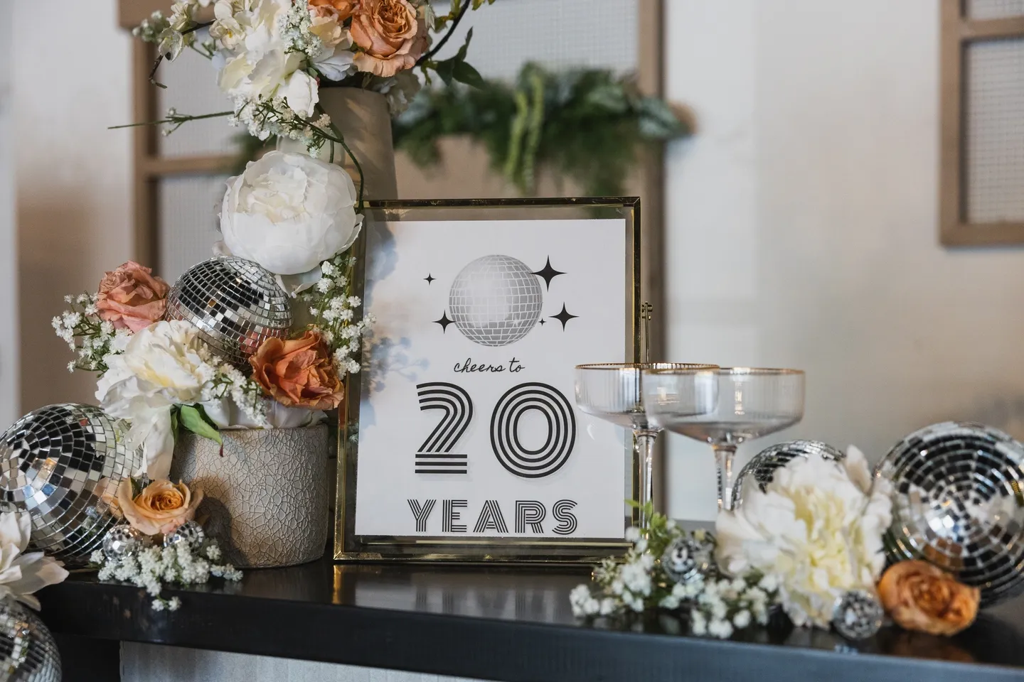 A table with flowers and a sign that says welcome to 2 0 years.